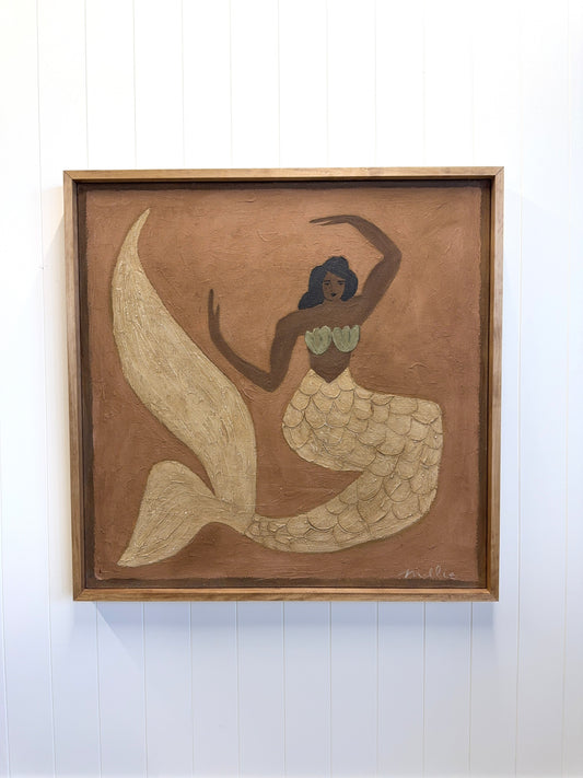 Framed artwork of a mermaid on a white wall